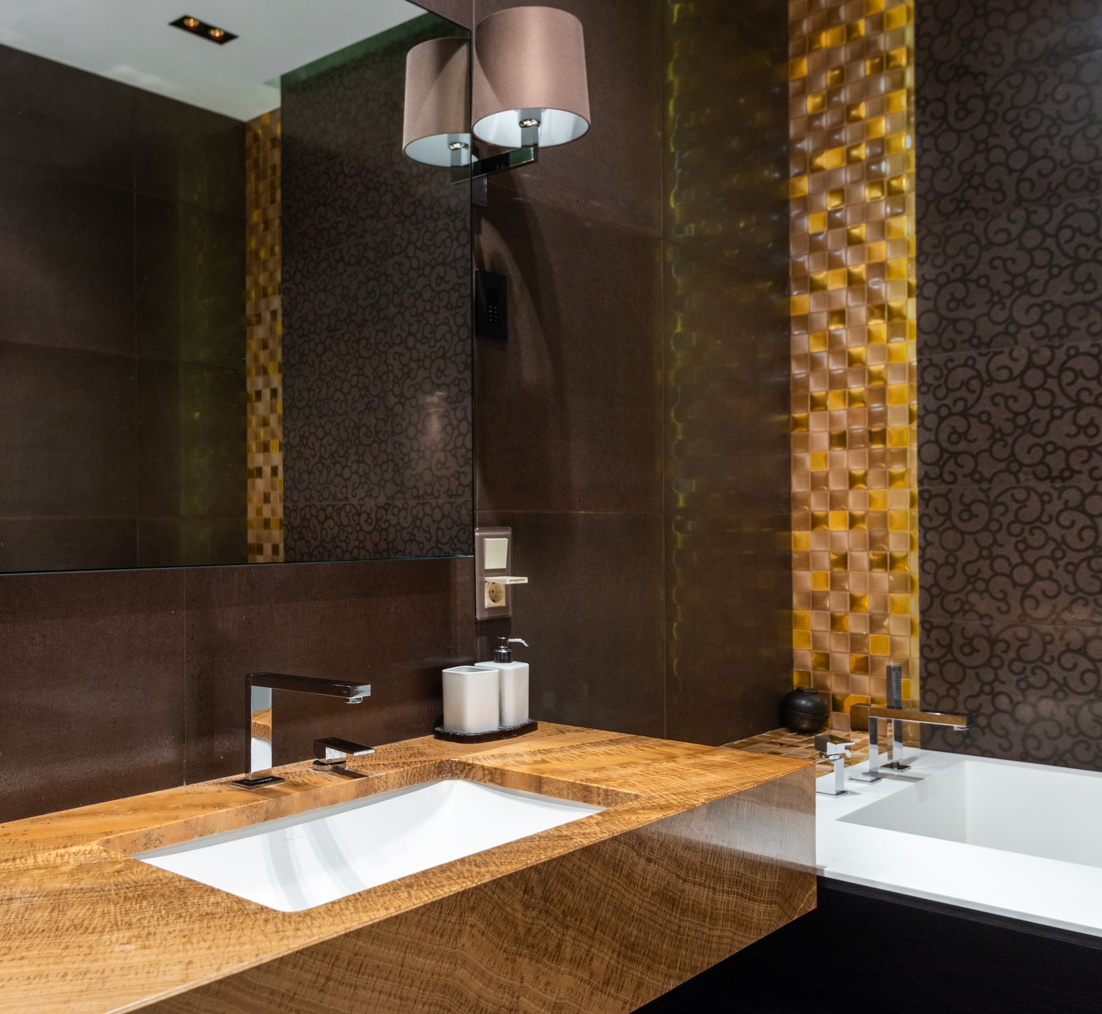 A bathroom with a wooden sink and patterned wall covering