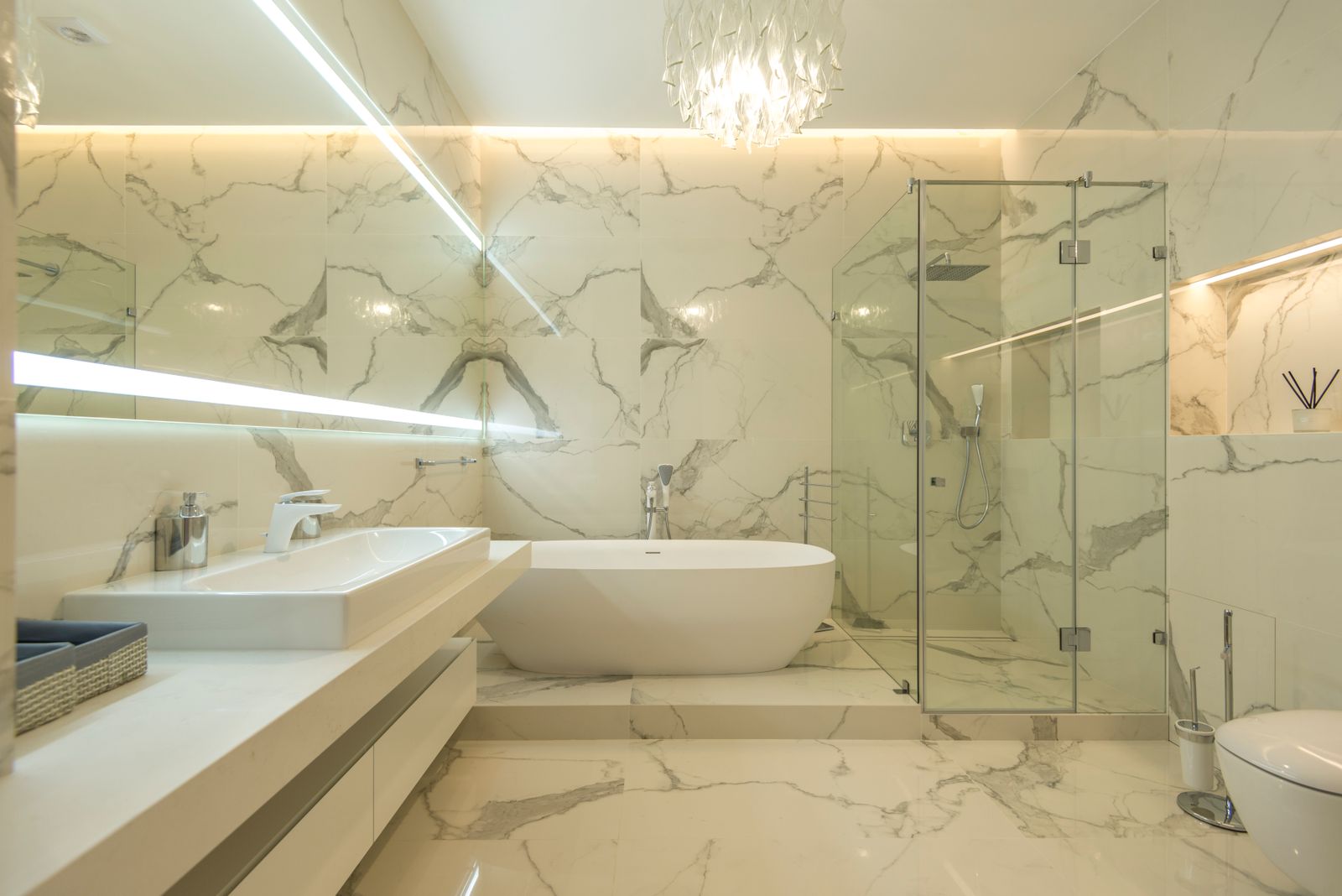 A freestanding stone tub set against a dark veined feature wall